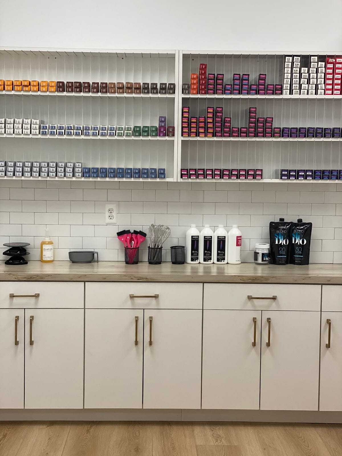 Hair salon shelf with colorful dye boxes, styling tools, and hair care products.