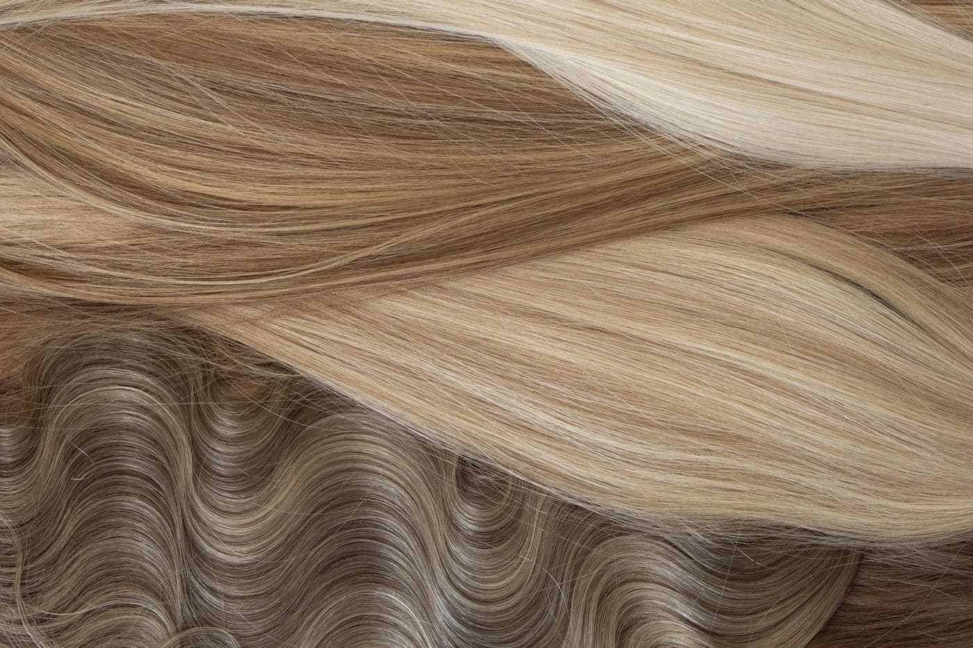 Various shades and textures of blonde and brown hair extensions displayed closely.